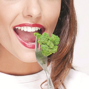 Close-up of a woman eating broccoli