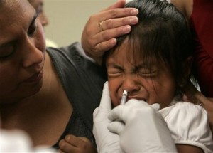 FILE - In this Tuesday, Oct. 6, 2009 file photo, Amparo Martinez, left, watches as her daughter, Sorayo Martinez, 4, is given a dose of swine flu vaccine in Oregon City, Ore. After shortages, swine flu vaccine is plentiful enough that nearly half the states now say everyone can get it, not just those in priority groups.  (AP Photo/Don Ryan, file)
