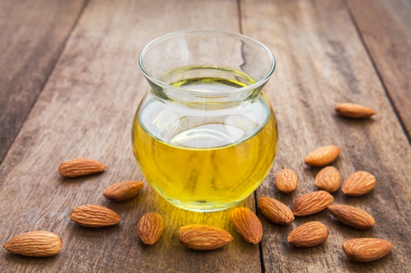 Almond oil in glass bottle and almonds